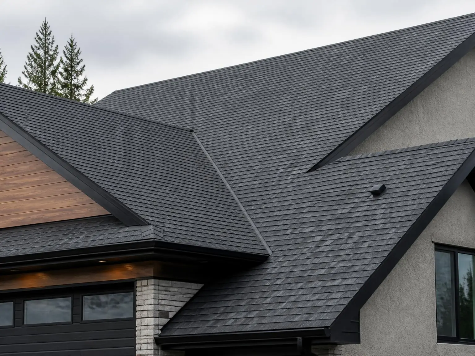 Close view of a finished charcoal shingle roof with clean valleys and flashing on a modern home